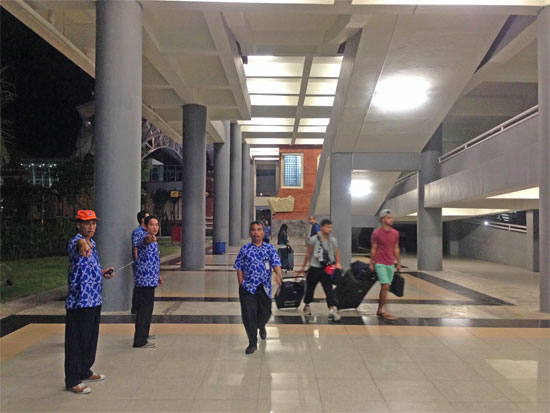 My 100,000 rupiah saviour approached. Note the tourists walking back into the terminal behind him.