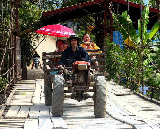Families go about their business in Vang Vieng despite the tourist masses