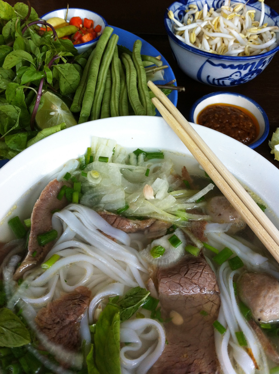 Lao pho is always served with a plate of herbs, greens and plenty of chilli