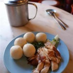 Chicken rice balls and a pot of chili sauce.