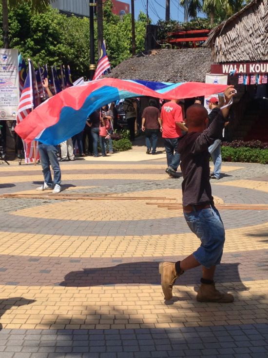 A Sabahan waves a flag during a march of solidarity for Malaysian soldiers