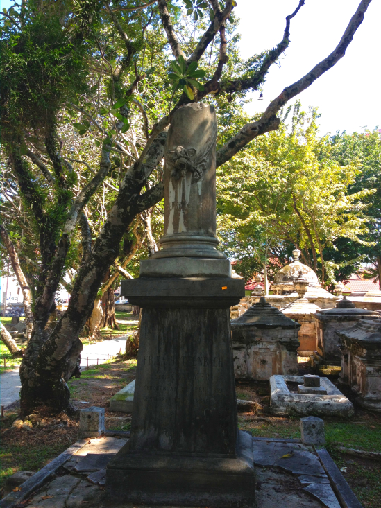 A headless angel atop a plinth dominates the dead, worthy of a gothic horror novel.