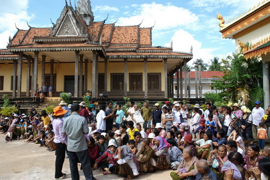 Families wait patiently in the sun