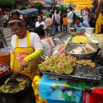 Frying up veggie rice cakes street side in Chinatown.
