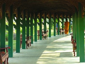 A monk strolls through one of Ancient Siam's many passages.