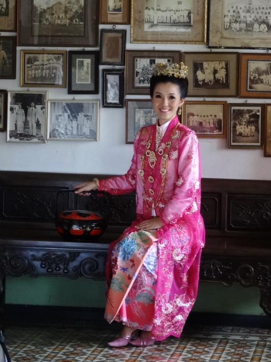 A bride in a traditional Baba-Peranakan (Straits Chinese) dress poses for a photo shoot.