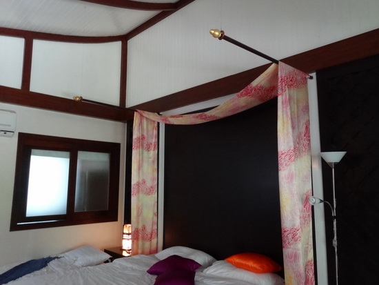 A big room with colourful accents and a cool curving roof.