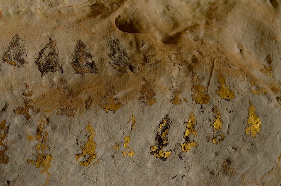Gold leaf remnants on a cave wall.