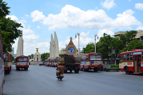City buses line up to shuttle protesters away from the Democracy Monument site.