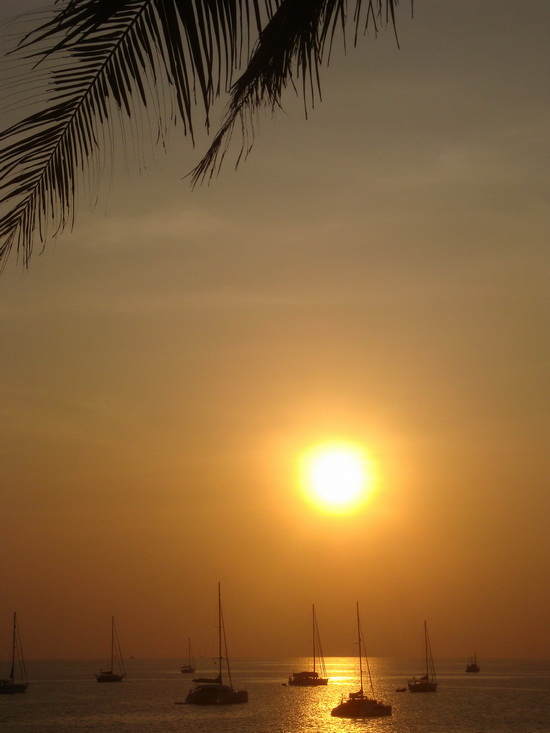 Sailboats at Nai Harn beach add a touch of glamour to the sunset scene.