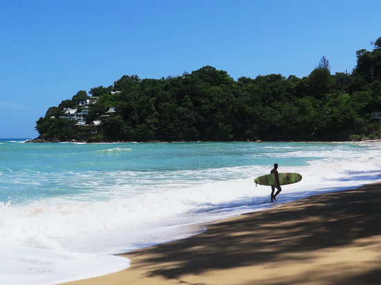 A solo surfer searches for some waves on Kamala beach.
