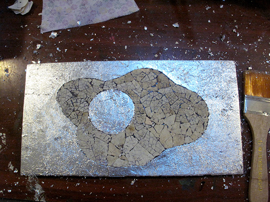 Lay on super thin pieces of silver leaf, again using paint as an adhesive.